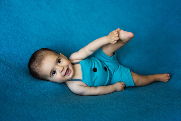 Aranyos újszülött. Boldog baba, kék háttérrel. Szoros portré újszülött babáról. Babaáru csomagolási sablon. Gyerekszoba. Orvosi és egészséges koncepció. Karácsonykor. Újév. - Fotó, kép