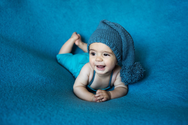 Cute newborn baby in the blue hat. Happy baby on a blue background. Closeup portrait of newborn baby. Baby goods packing template. Nursery. Medical and healthy concept. Christmas. New Year - Photo, Image