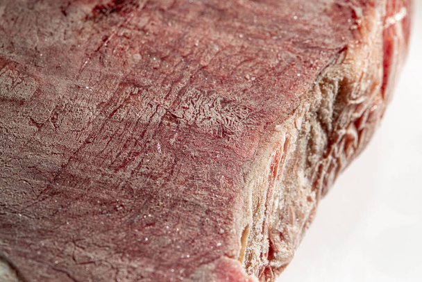 Seção transversal de carne de vaca congelada em um prato branco. Fotografia macro. - Foto, Imagem