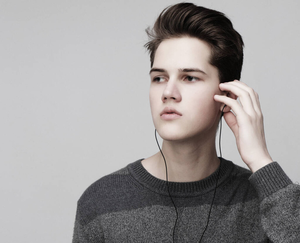 Modern teenage boy enjoys the music in headphones - 写真・画像