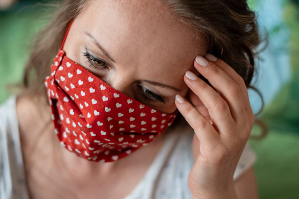 Porträt einer Frau mit handgemachter Baumwollmaske. Schutz gegen Speichel, Husten, Staub, Umweltverschmutzung, Viren, Bakterien, COVID-19. Coronavirus-Patient. - Foto, Bild