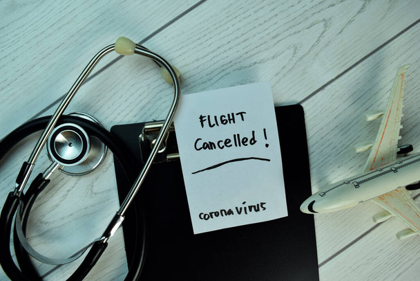 Flug abgesagt - Coronavirus auf klebrigen Zetteln isoliert auf Holztisch. - Foto, Bild