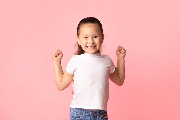 Szczęśliwy mały azjatycki dziewczyna wstrząsające pięści, co zwycięzca gest - Zdjęcie, obraz
