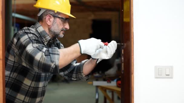Carpenter worker at work with screwdriver, repairs and installs the door frame of a room. Construction industry. Carpentry. Footage. - Footage, Video