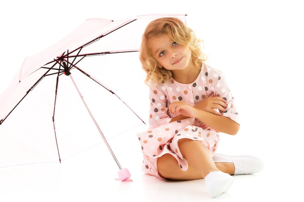 Little girl under an umbrella.Concept style and fashion. Isolated on white background. - Fotó, kép