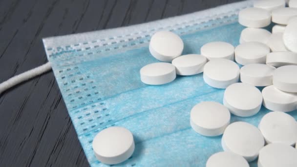 Uma pilha de pílulas brancas em uma máscara médica azul protetora de perto. Macro shot - Filmagem, Vídeo
