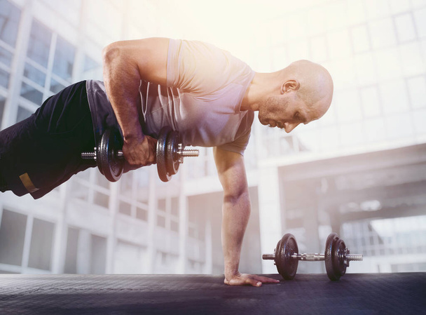 Спортсмен тренує м'язи у спортзалі
 - Фото, зображення
