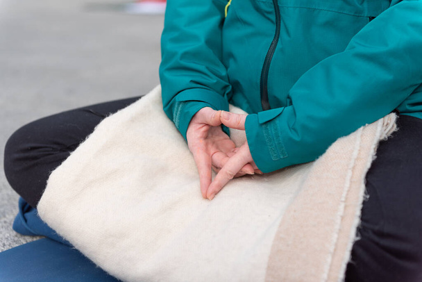 Yoga teachers protesting against the blockade and restrictions of Covid-19 in a square in Brescia, Italy. Shot of the hands resting on the knees of the crossed legs. People are meditating. - Photo, Image