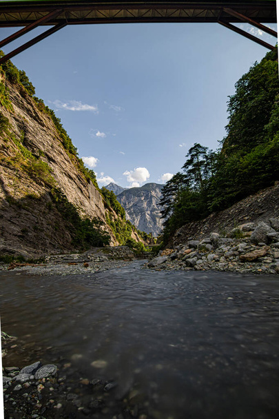 Ποταμός ρέει μέσα από την κοιλάδα σε μια ηλιόλουστη μέρα του καλοκαιριού. Ελβετία - Φωτογραφία, εικόνα
