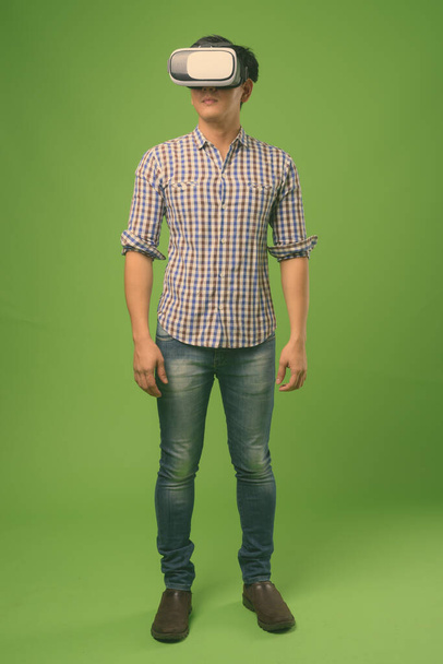Young handsome Filipino man against green background - Foto, Imagem