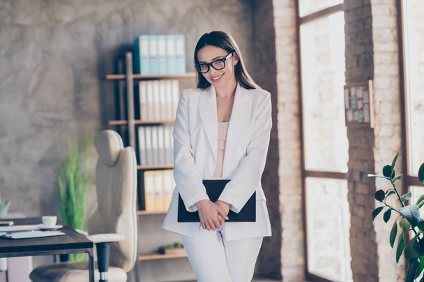 Photo of attractive beautiful business lady hold arms clipboard self-confident person friendly smile home spacious office social distance formal wear blazer pants white suit specs indoors - Foto, Imagen
