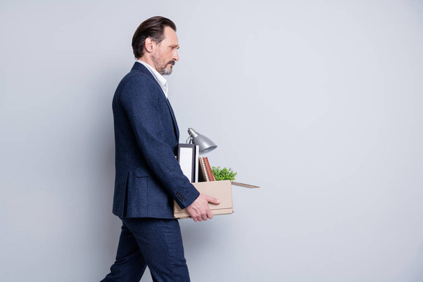 Profile photo of unhappy stressed worker mature guy jobless hopeless financial crisis hold carton box belongings fired quit tired walk home from office wear suit isolated grey background - Fotografie, Obrázek