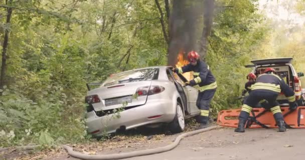 Bomberos rescatando pareja de coche en llamas - Metraje, vídeo