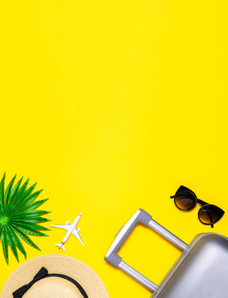 Sfondo spiaggia. Accessori donna viaggiatore: valigia, aereo bianco, occhiali da sole su sfondo giallo con spazio vuoto per il testo. Progettazione del concetto di vacanza estiva - Foto, immagini