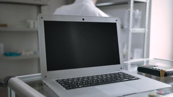 薬局でノートパソコンの画面バックグラウンドで薬剤師と追跡する準備ができて - 映像、動画