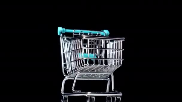 Empty shopping cart close-up on a black background. Black Friday and Business Crisis Concept due to Coronavirus Pandemic Lockdown. Slow rotation - Footage, Video