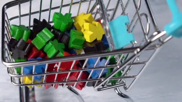 Colored wooden shapes in a mini supermarket trolley. Rotation. Slow motion. The idea of buying kids games for fine motor skills - Materiaali, video