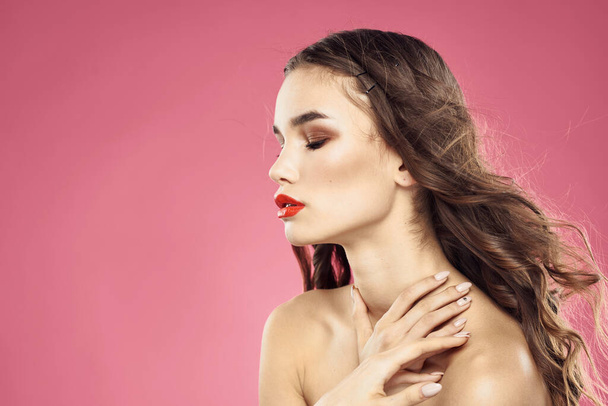 Beautiful woman with red lips on a pink background nude shoulders cropped view - Photo, Image