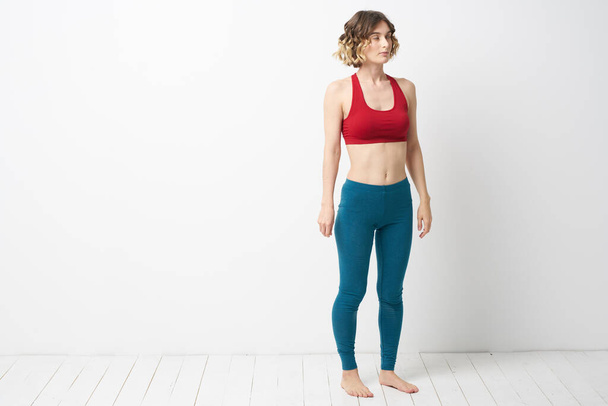 Frau in Leggings turnt in einem hellen Raum schlanke Figur Fitness-Sport - Foto, Bild