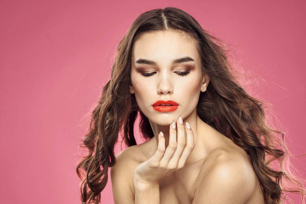 Houkutteleva nainen muodikas kampauksen paljasti olkapäät ja punaiset huulet vaaleanpunainen tausta - Valokuva, kuva