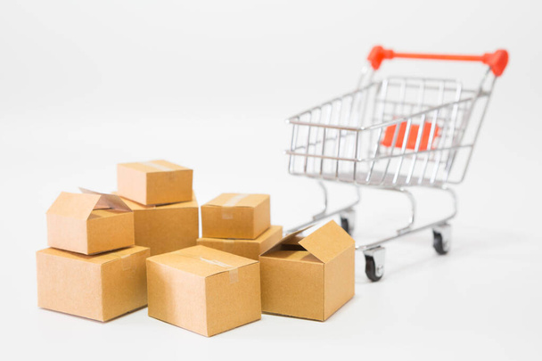 Molte scatole dei pacchi e un carrello della spesa su sfondo bianco per il concetto di shopping online - Foto, immagini