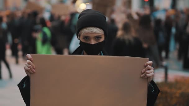 Protest en demonstraties. opstandige vrouw met gezichtsmasker opvallend  - Video