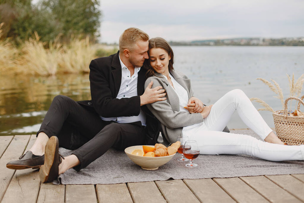 People sitting by the water with picnic set - Photo, Image