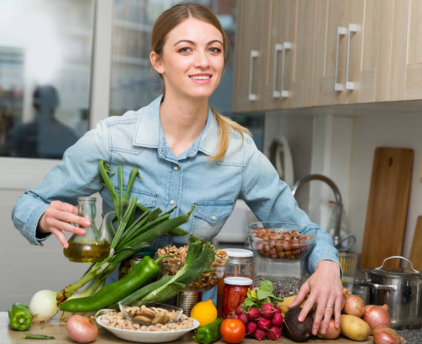 Portrait of happy housewife with vegetables and herbs - Foto, imagen