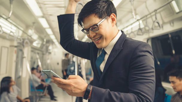 Uomo d'affari che utilizza il telefono cellulare sul treno pubblico - Foto, immagini