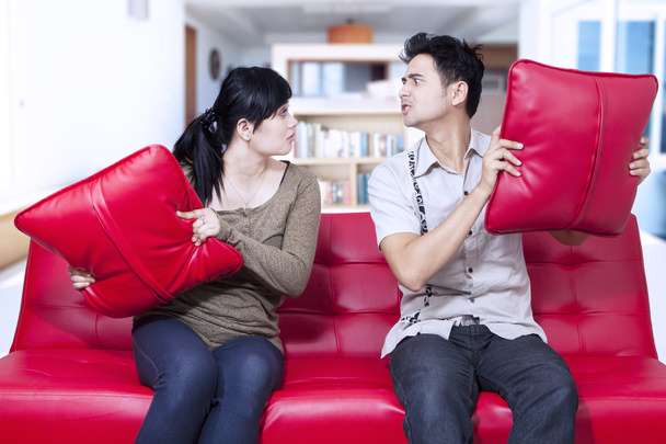 Angry couple on red sofa at home - Foto, immagini