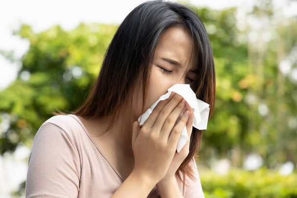 sick asian woman sneezing and having runny nose; concept of allergy, flu virus outbreak, health care, disease spreading, coronavirus outbreak control, COVID-19 pandemic - Foto, imagen