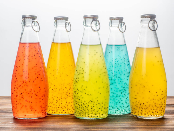 Five bottles of Basil Seed on a white background. Red, yellow, light blue and green color - Fotó, kép