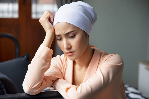 Portrait of sad asian woman cancer patient wearing head scarf after suffering serious hair loss due to chemotherapy - Photo, Image