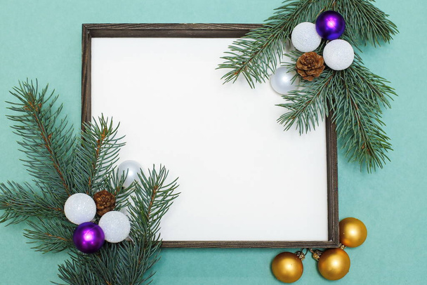 Christmas composition of fir branches, pine cones, Christmas toys and decorations. Christmas frame with space for text on a light green background - Φωτογραφία, εικόνα