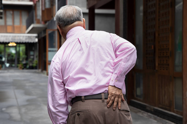 Старий азіатський старший чоловік, який страждає від грижі диска, перенесення спини, болю у спині, артриту подагри, остеопорозу. - Фото, зображення