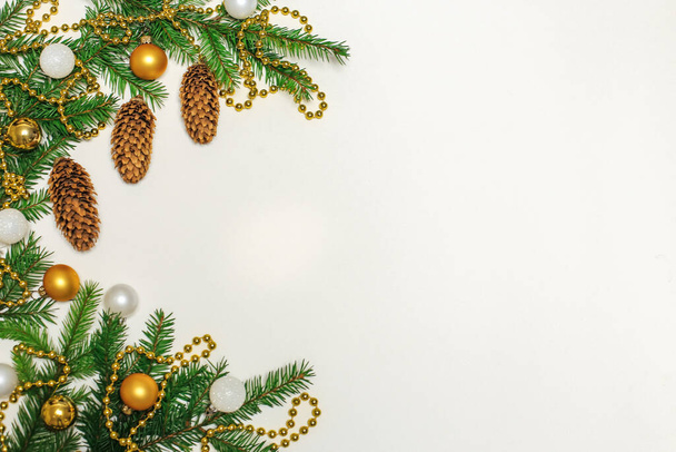 Рождественская композиция подарки, еловые ветви и конусы, золотые украшения, новогодняя концепция. плоская планировка, место для текста - Фото, изображение
