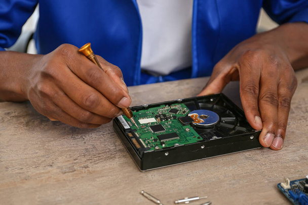 Afroamerikanischer Techniker repariert Computer im Service Center, Nahaufnahme - Foto, Bild