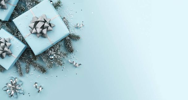 Weihnachtsgeschenkboxen mit silbernen Bändern, Dekoration, Schleifen, Funkeln, Tannenzweigen, Schneeflocken und Konfetti auf blauem Hintergrund. Weihnachts- und Neujahrsgrußkarte, Winterurlaub. Ansicht von oben, Banner - Foto, Bild