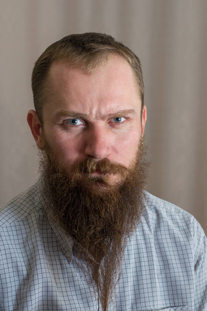 Portrait of a white serious angry man with a long beard - Фото, зображення