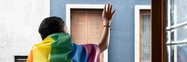 LGBTの虹の旗を持つ黒人アフリカのLGBT女性、レズビアンの誇りやLGBTの誇り運動、包括性、人々の概念の多様性 - 写真・画像