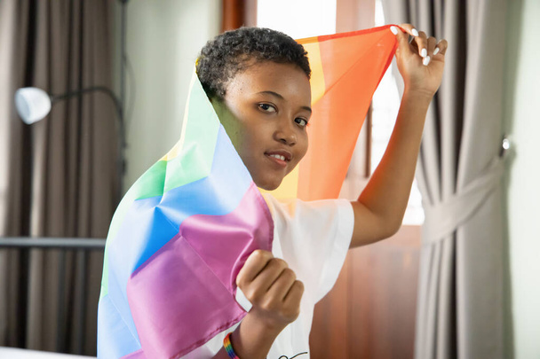 Musta Afrikkalainen LGBT nainen tilalla LGBTQ sateenkaaren lippu, lesbo ylpeys tai LGBT ylpeys liike, osallisuus, monimuotoisuus ihmisten käsite - Valokuva, kuva
