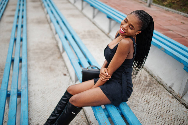Young stylish sexy beautiful african american woman in street at the stadium bleachers, wearing on black. - Фото, зображення
