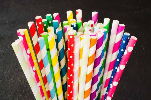 Colorful paper straws of different colors for cocktails and drinks on dark background. - Photo, Image