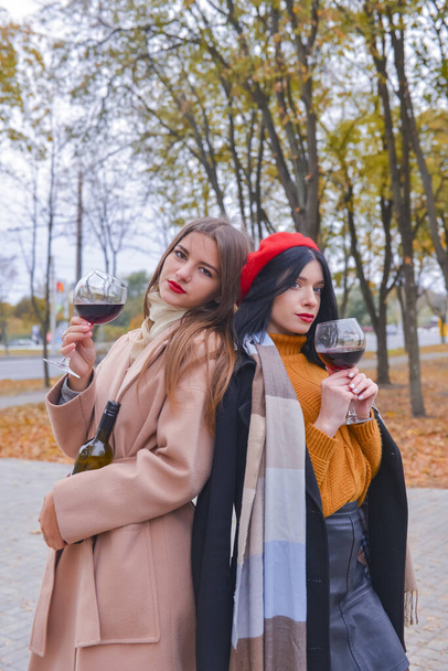 Two pretty cheerful women with glasses of wine outside. Leisure time, still life, eating out concept. - Foto, immagini