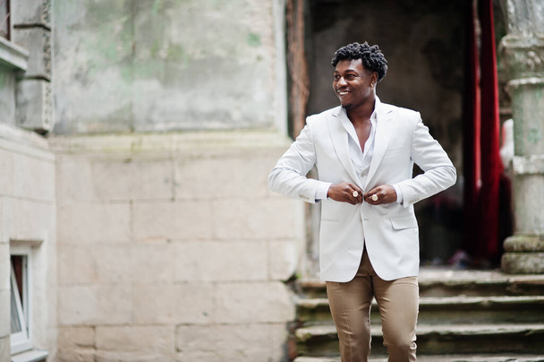 Thoughtful young handsome african american gentleman in formalwear. Black stylish model man in white jacket. - 写真・画像