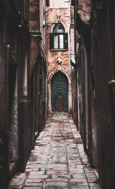 A vertical shot of an old blue door in the narrow street in Venice - Фото, зображення