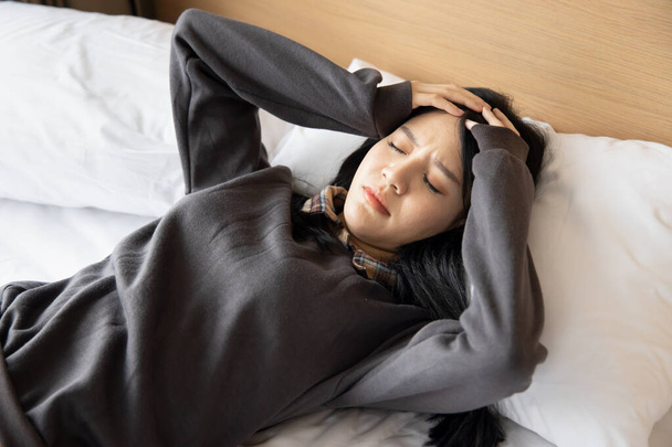 Hasta kadın baş ağrısı, stres, ateş, soğuk algınlığı, COVID-19 gribi veya koronavirüs enfeksiyonu ile uyuyor. - Fotoğraf, Görsel