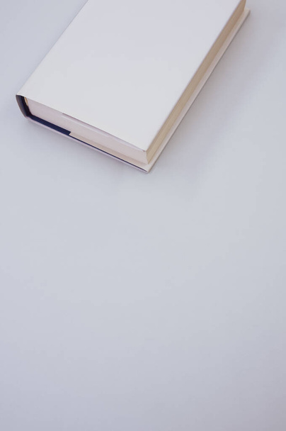Vista superior vertical de un libro blanco aislado sobre un fondo blanco sucio - espacio para copiar - Foto, Imagen