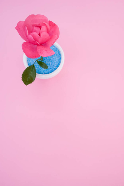 A top view of a decorative artificial  pink rose in a pot on the pink surface - space for text - Valokuva, kuva