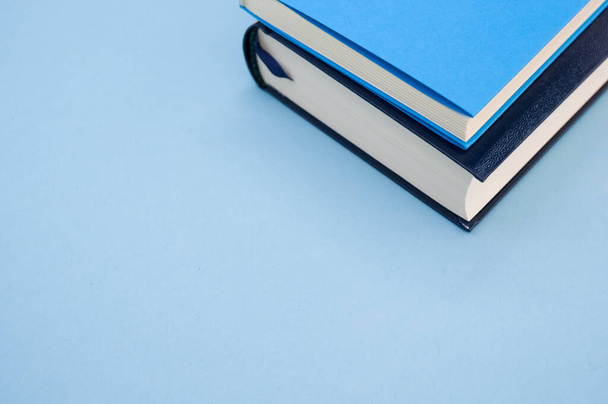 A closeup  of the hardcover books on the blue surface - space for text - Fotó, kép